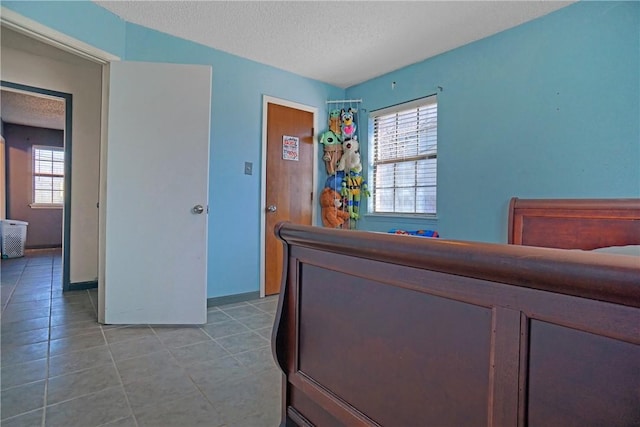 bedroom with light tile patterned floors and a textured ceiling