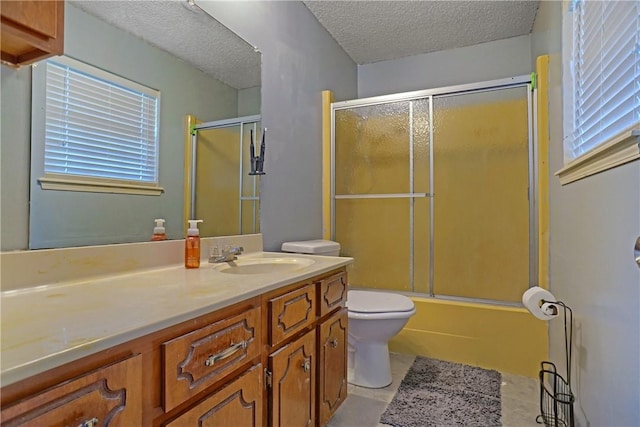 full bathroom featuring combined bath / shower with glass door, toilet, a textured ceiling, vanity, and tile patterned flooring