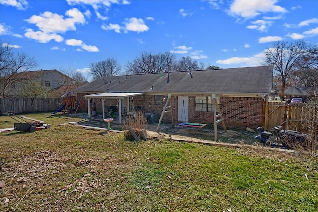 back of property featuring a patio area, brick siding, a fenced backyard, a yard, and a playground