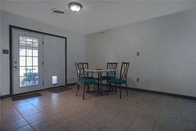 tiled dining area with visible vents and baseboards