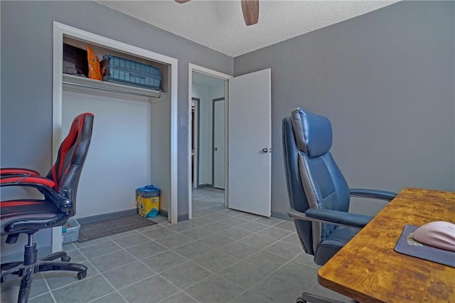 home office with tile patterned floors, ceiling fan, baseboards, and a textured ceiling