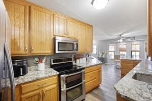 15515 Ar-105, Hector, AR 72843 - kitchen with light brown cabinets, light wood-type flooring, a ceiling fan, light stone countertops, and stainless steel appliances