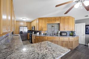 15515 Ar-105, Hector, AR 72843 - kitchen with ceiling fan, range, stainless steel fridge, and light stone countertops
