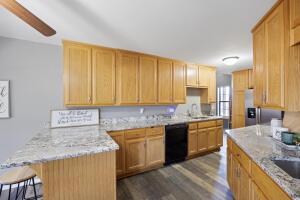 15515 Ar-105, Hector, AR 72843 - kitchen featuring a breakfast bar, light stone counters, a peninsula, dark wood-type flooring, and dishwasher