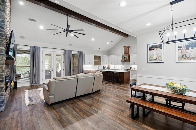 251 Kordsmeier Ln, Morrilton, AR 72110 - living room featuring beamed ceiling, a fireplace, a ceiling fan, dark wood-type flooring, and wainscoting