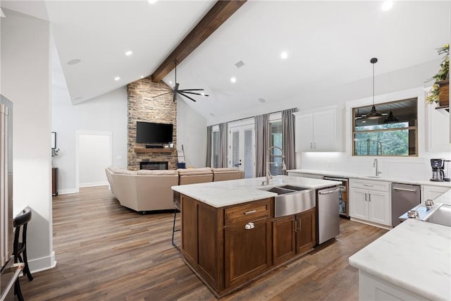 251 Kordsmeier Ln, Morrilton, AR 72110 - kitchen featuring a ceiling fan, a stone fireplace, dark wood-type flooring, an island with sink, and a sink