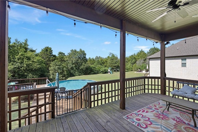 251 Kordsmeier Ln, Morrilton, AR 72110 - deck with a yard, a ceiling fan, an outdoor pool, view of wooded area, and a playground