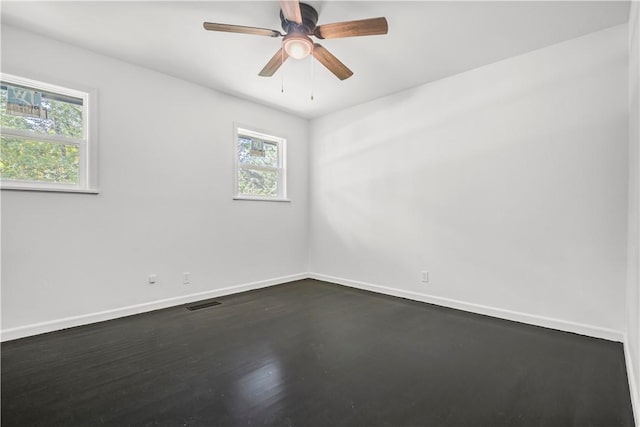 922 Scenic Dr, Perryville, AR 72126 - empty room featuring plenty of natural light, baseboards, a ceiling fan, and dark wood-style flooring