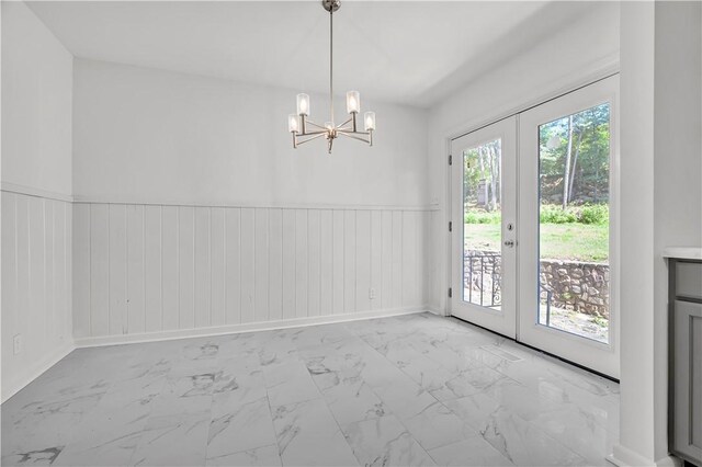922 Scenic Dr, Perryville, AR 72126 - unfurnished dining area featuring marble finish flooring, a chandelier, wainscoting, french doors, and wooden walls