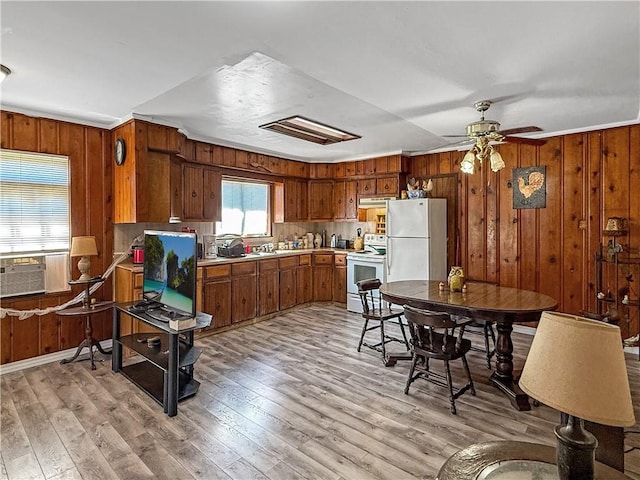 206 Arkansas St, Danville, AR 72833 - kitchen featuring white appliances, brown cabinets, wood walls, light countertops, and light wood-type flooring