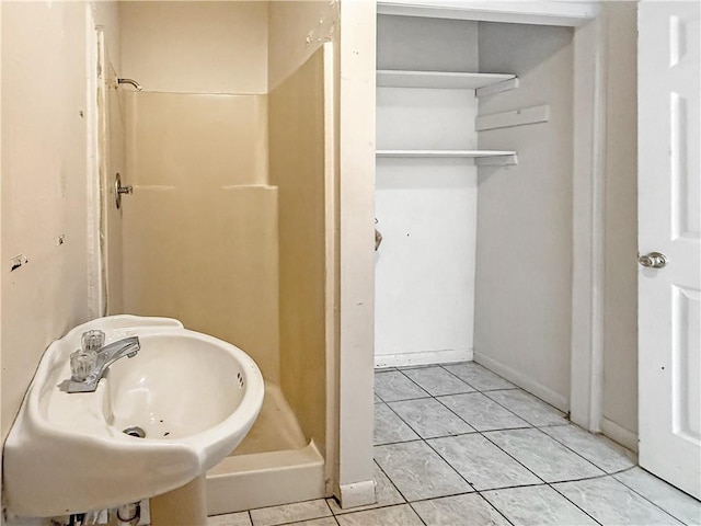 206 Arkansas St, Danville, AR 72833 - bathroom with a shower stall, a sink, and tile patterned floors