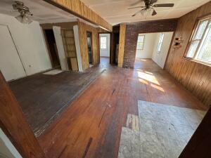 281 Blackwell Rd, Atkins, AR 72823 - unfurnished living room with ceiling fan, wooden walls, and wood finished floors
