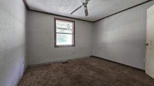 empty room featuring a ceiling fan and carpet flooring