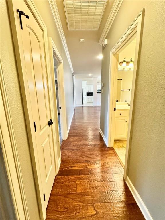 335 Point W, Conway, AR 72034 - hallway with baseboards, visible vents, crown molding, and dark wood-style floors