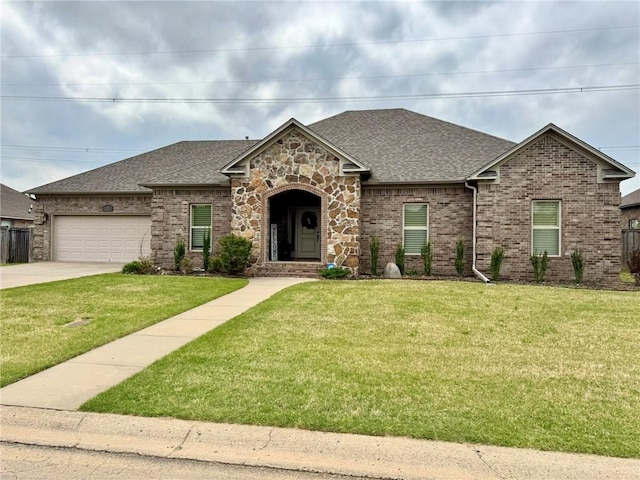 335 Point W, Conway, AR 72034 - view of front of home with a shingled roof, a front lawn, concrete driveway, brick siding, and a garage