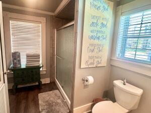 2816 Honeysuckle Ln, Russellville, AR 72801 - bathroom with a shower stall, toilet, wood finished floors, baseboards, and ornamental molding