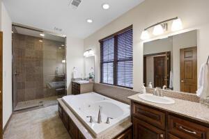 bathroom with a shower stall, vanity, a bath, and visible vents
