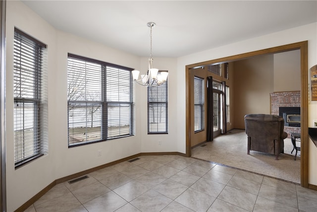 279 Eagle Cove Rd, Lamar, AR 72846 - unfurnished dining area featuring a chandelier, light tile patterned floors, a brick fireplace, and baseboards