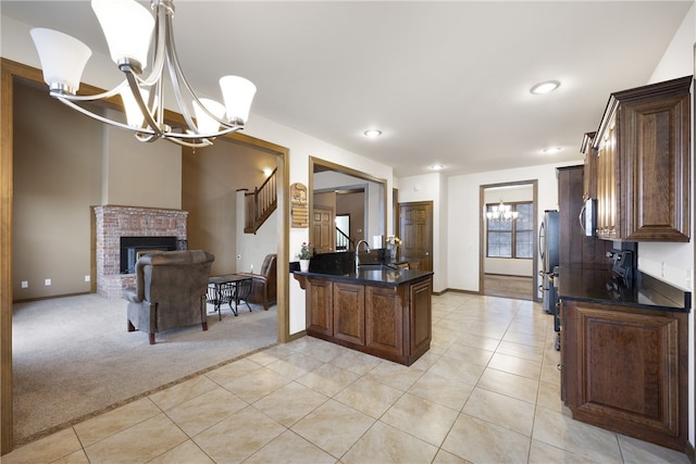 279 Eagle Cove Rd, Lamar, AR 72846 - kitchen featuring a chandelier, light tile patterned floors, a sink, a brick fireplace, and light colored carpet