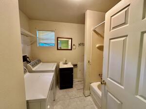 314 Leigh St, Ola, AR 72853 - washroom with light tile patterned floors, washer and clothes dryer, and a sink