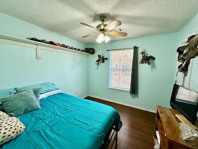 6011 River Rd, Pottsville, AR 72858 - bedroom featuring wood finished floors, a textured ceiling, a ceiling fan, and baseboards