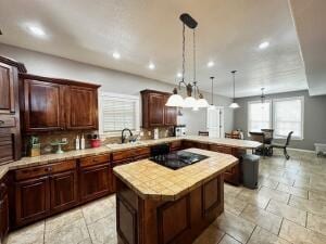 28 Angelfish Ct, Russellville, AR 72802 - kitchen with black electric cooktop, a sink, light countertops, a peninsula, and a kitchen island