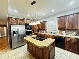 28 Angelfish Ct, Russellville, AR 72802 - kitchen featuring tasteful backsplash, black appliances, a center island, light countertops, and decorative light fixtures
