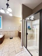 28 Angelfish Ct, Russellville, AR 72802 - full bath featuring a shower stall, wainscoting, tile patterned flooring, and tile walls