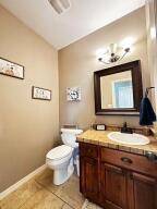 28 Angelfish Ct, Russellville, AR 72802 - bathroom featuring vanity, vaulted ceiling, toilet, tile patterned floors, and baseboards