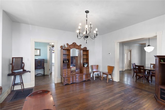 601 N Front St, Dardanelle, AR 72834 - dining area with a wood stove, a notable chandelier, baseboards, and dark wood finished floors