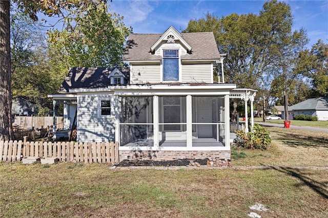 601 N Front St, Dardanelle, AR 72834 - back of property with a sunroom, roof with shingles, fence, and a lawn
