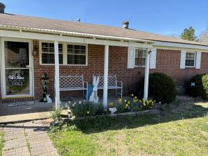 rear view of property with brick siding and a lawn