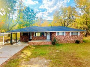 ranch-style home with concrete driveway and a front yard