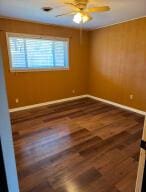 empty room with baseboards, a ceiling fan, and wood finished floors