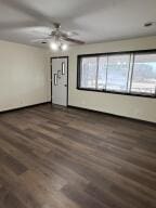 unfurnished living room with dark wood-type flooring and ceiling fan