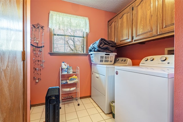 washroom with washer and clothes dryer, cabinet space, light tile patterned floors, and a textured ceiling