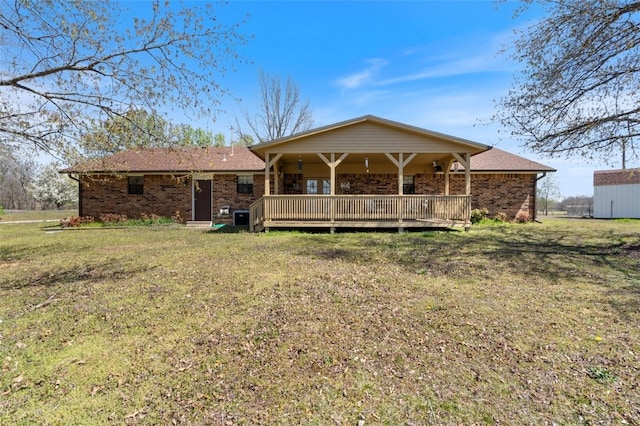 back of house with brick siding and a yard