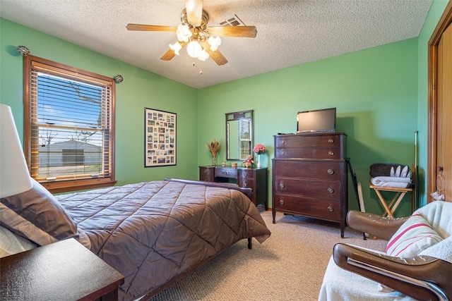 carpeted bedroom with a textured ceiling, ceiling fan, and visible vents