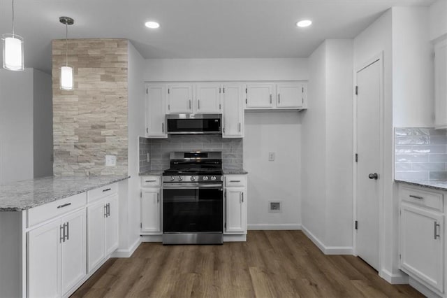 kitchen with stainless steel appliances, white cabinetry, light stone countertops, decorative backsplash, and dark wood-style flooring