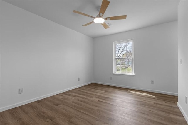 spare room with baseboards, a ceiling fan, and wood finished floors