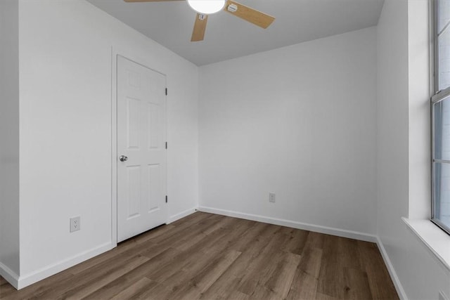 empty room with baseboards, a ceiling fan, and wood finished floors
