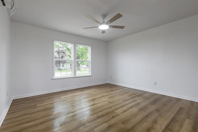 spare room with wood finished floors, baseboards, and ceiling fan