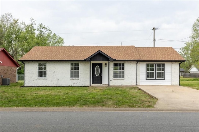 single story home featuring central AC, a shingled roof, and a front yard