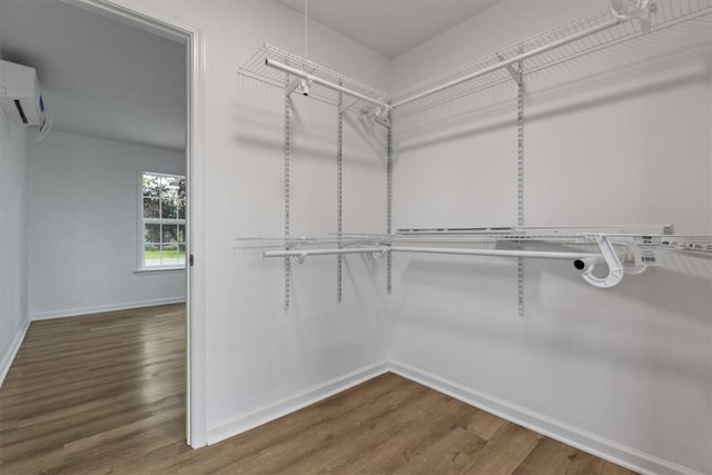 walk in closet featuring a wall mounted AC and wood finished floors