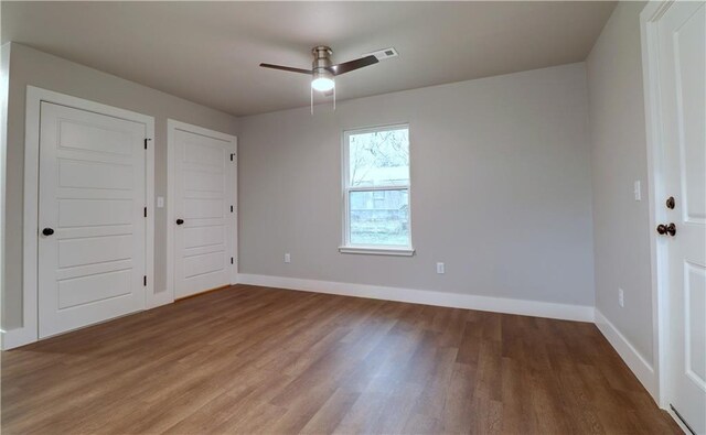 402 NE 4th Ave, Gravette, AR 72736 - empty room with wood finished floors, baseboards, and ceiling fan