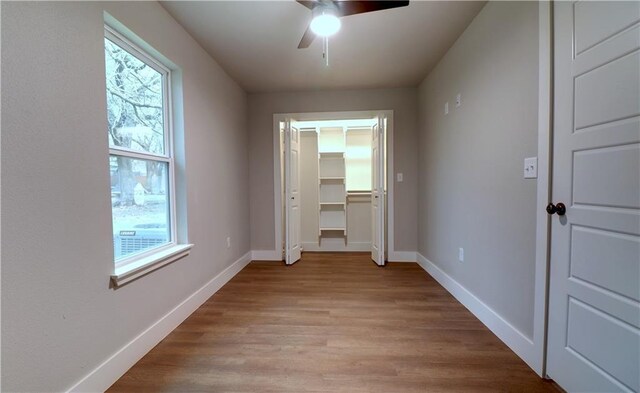 402 NE 4th Ave, Gravette, AR 72736 - unfurnished bedroom with light wood-type flooring, baseboards, and ceiling fan