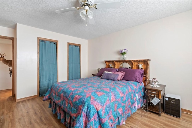 22965 Davis Valley Rd, Gentry, AR 72734 - bedroom featuring baseboards, wood finished floors, ceiling fan, and a textured ceiling