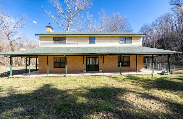 22965 Davis Valley Rd, Gentry, AR 72734 - back of property with a patio, a chimney, brick siding, and a yard