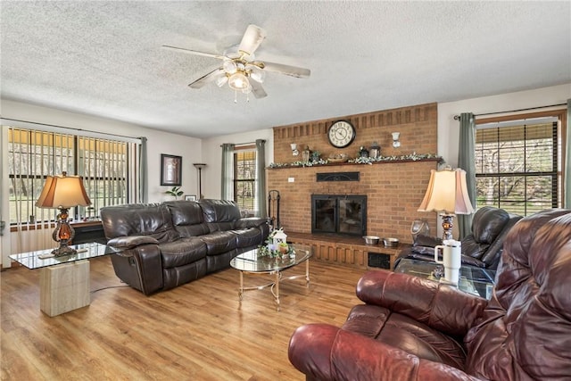 22965 Davis Valley Rd, Gentry, AR 72734 - living area featuring a wealth of natural light, wood finished floors, a ceiling fan, and a brick fireplace