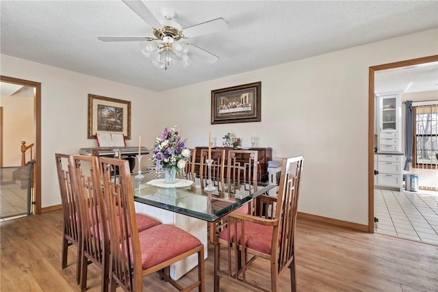 22965 Davis Valley Rd, Gentry, AR 72734 - dining area featuring baseboards, a textured ceiling, light wood-style flooring, and a ceiling fan